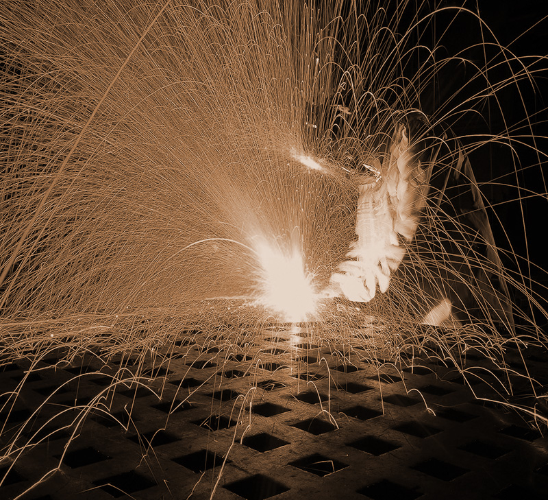 photo of a welder working in the dark